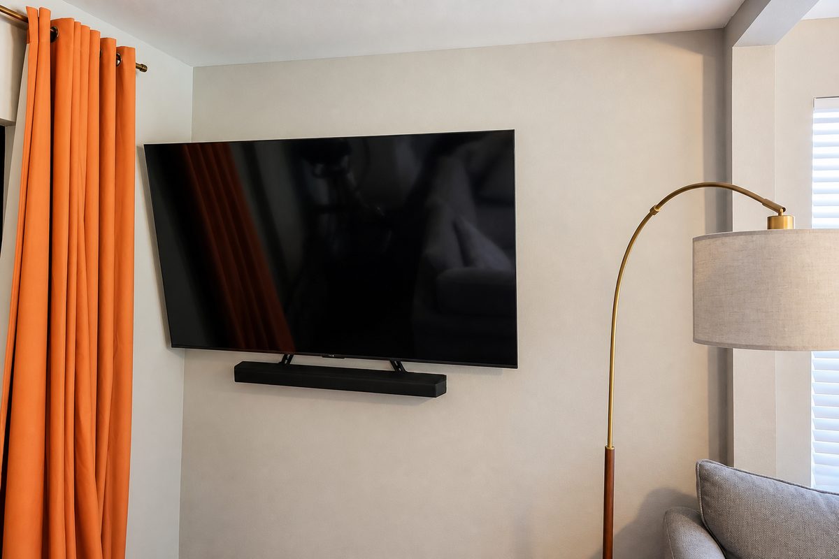 TV on a full-motion mount with a soundbar underneath